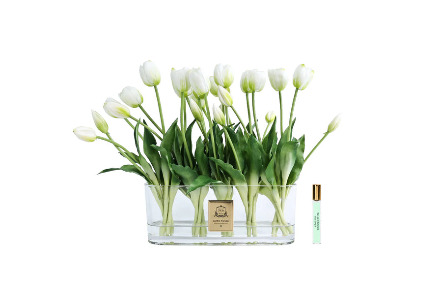 Cote Noire Clear glass vase with white tulips and a small bottle on a white background